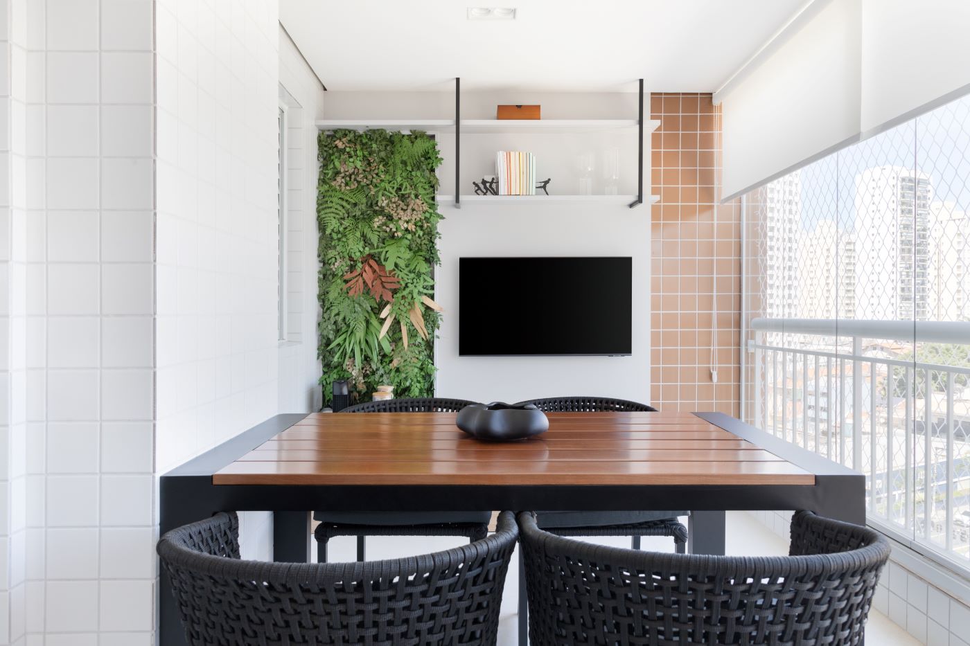 A mesma varanda pronta, com o jardim vertical, o painel e a mesa de madeira