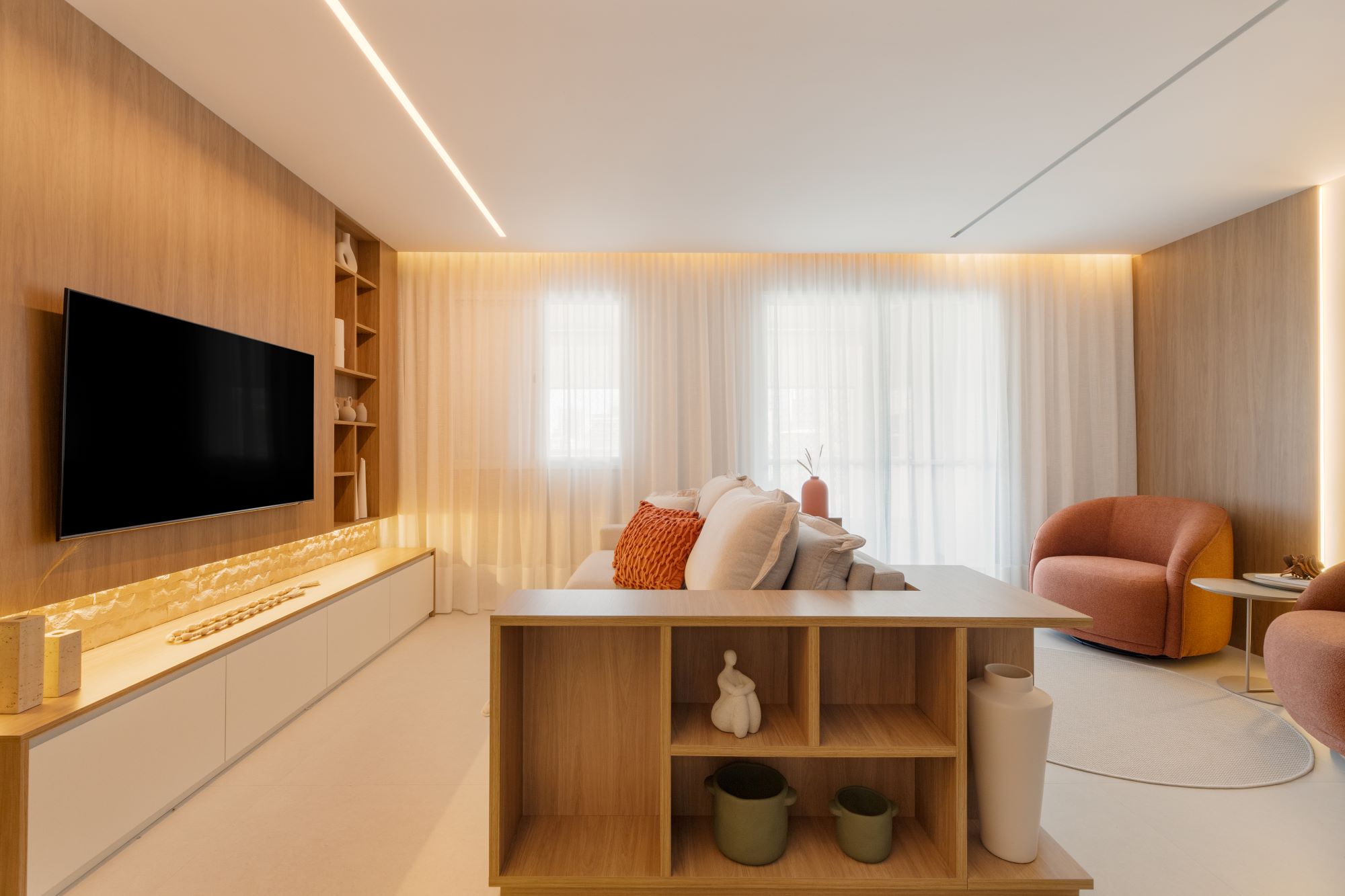 Projeto ES: sala de estar com painel de madeira iluminado, estante e poltronas terracota