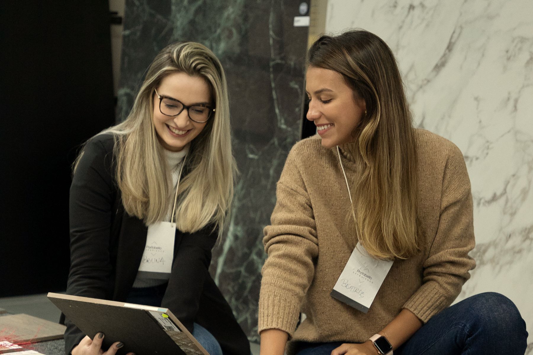 Beatriz Karpuk e Bruna Mello escolhendo amostras de revestimento num showroom